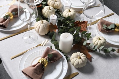 Photo of Beautiful autumn table setting. Plates, cutlery, glasses, pumpkins and floral decor