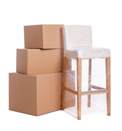 Chair wrapped in stretch film and boxes on white background