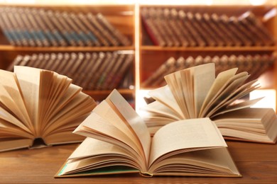 Open books on wooden table in library