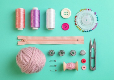 Photo of Flat lay composition with different threads and sewing accessories on color background