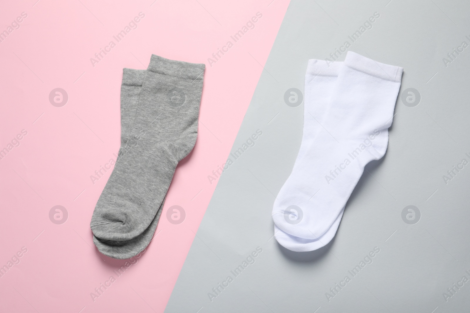 Photo of White and grey socks on color background, flat lay