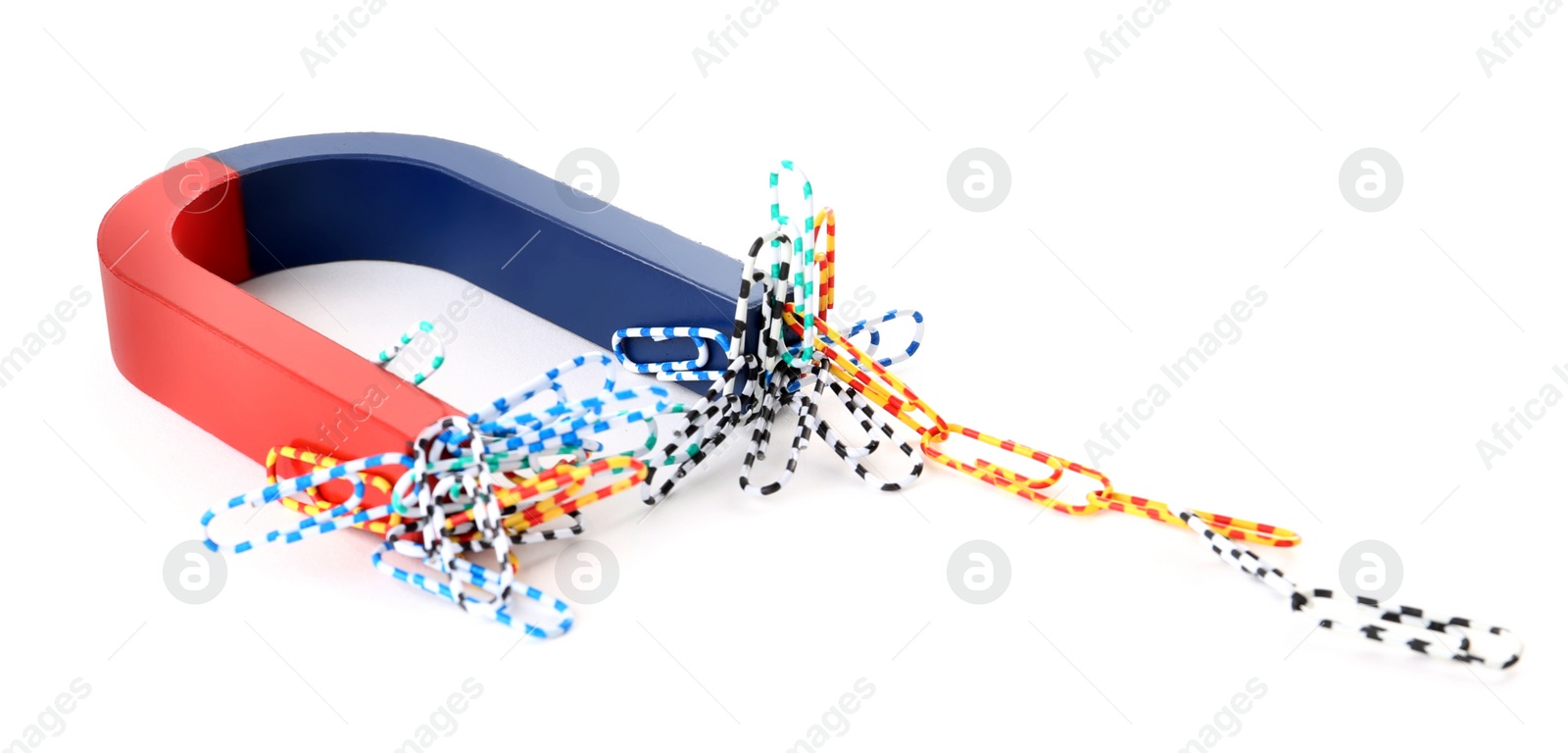 Photo of Magnet attracting paper clips on white background