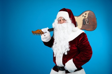Photo of Santa Claus with electric guitar on blue background, space for text. Christmas music