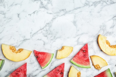Photo of Flat lay composition with tasty sliced melon and watermelon on marble background. Space for text
