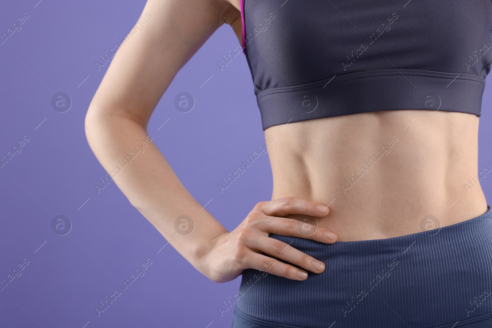 Photo of Woman wearing sportswear on violet background, closeup. Space for text