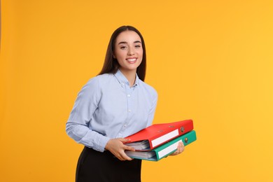 Happy woman with folder on orange background
