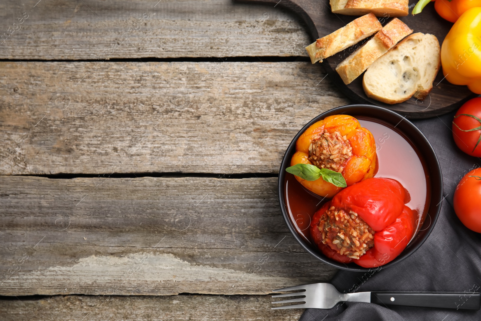 Photo of Delicious stuffed peppers served on wooden table, flat lay. Space for text