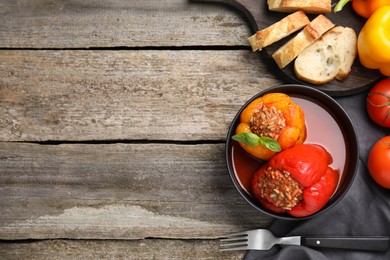 Photo of Delicious stuffed peppers served on wooden table, flat lay. Space for text