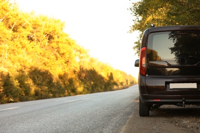 Photo of Car parked on country road. Space for text