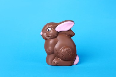 Photo of Chocolate bunny on light blue background. Easter celebration