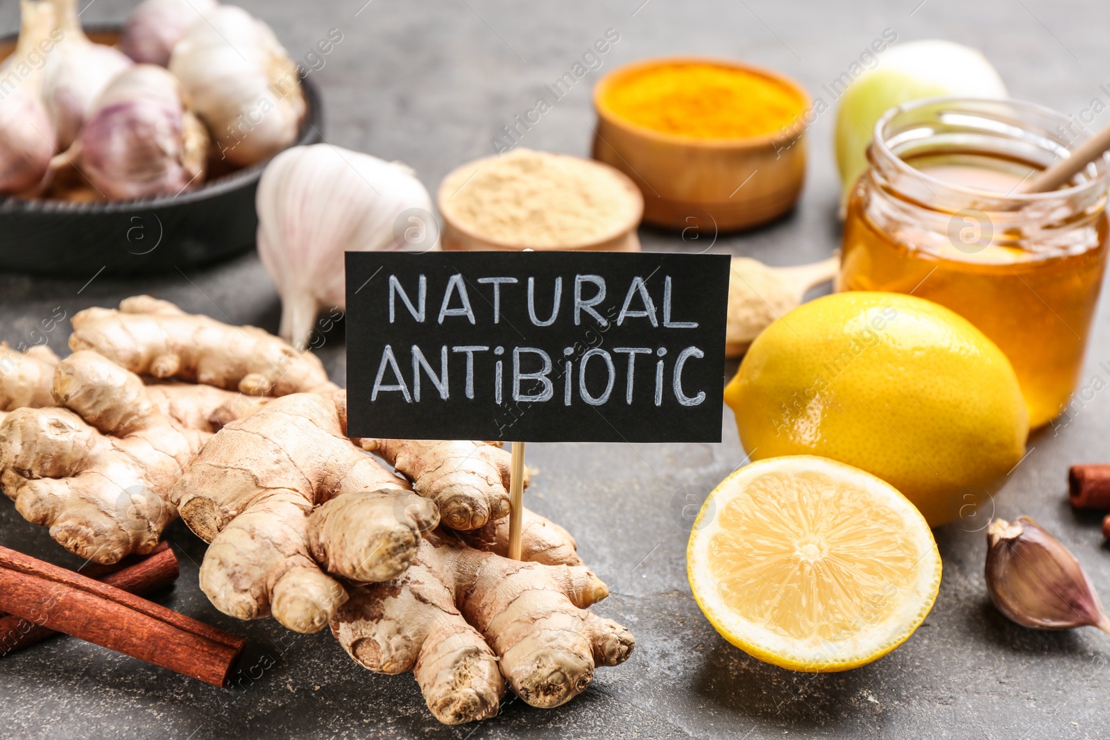 Photo of Different fresh products and card with phrase Natural Antibiotic on grey table