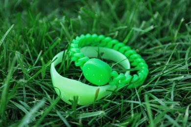 Photo of Insect repellent wrist bands on grass outdoors, closeup