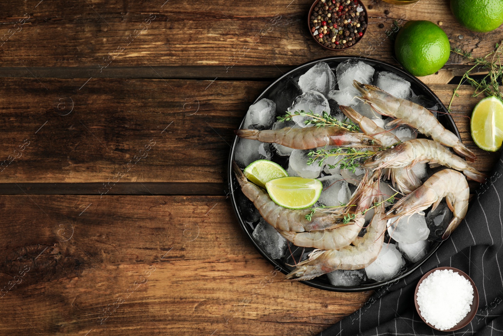 Photo of Flat lay composition with raw shrimps on wooden table. Space for text