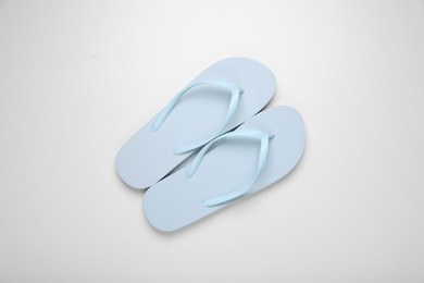 Photo of Light blue flip flops on white background, top view