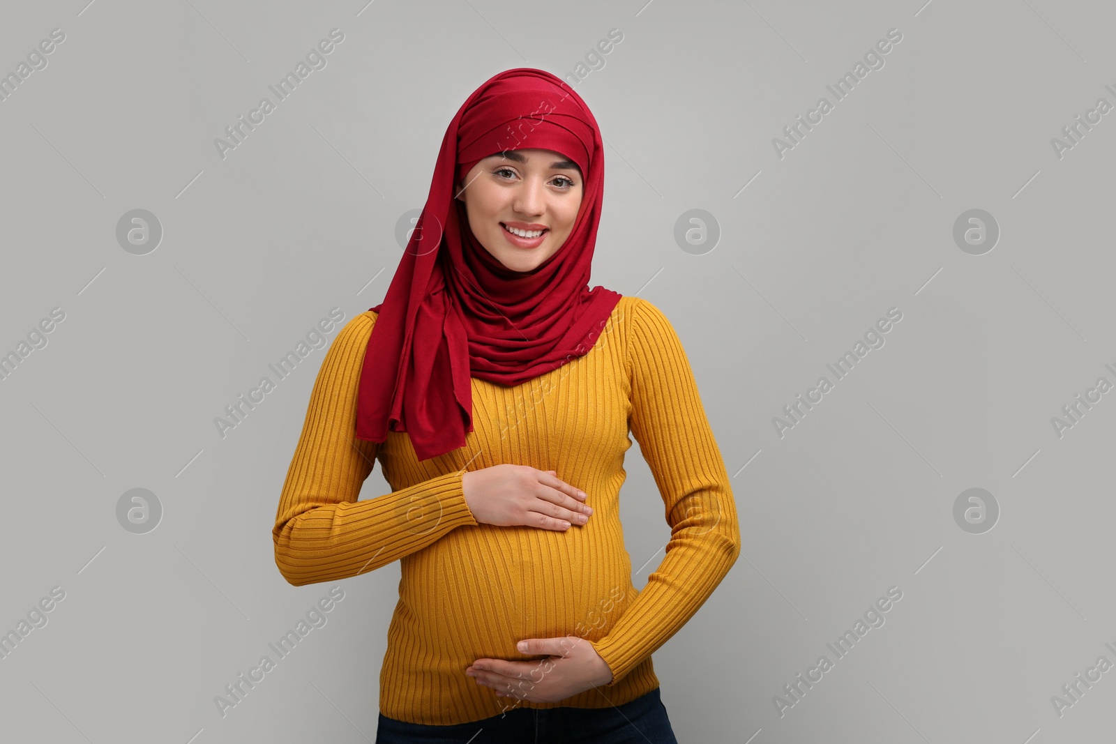 Photo of Portrait of pregnant Muslim woman in hijab on light gray background