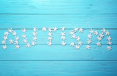 Word AUTISM made with puzzles on wooden background