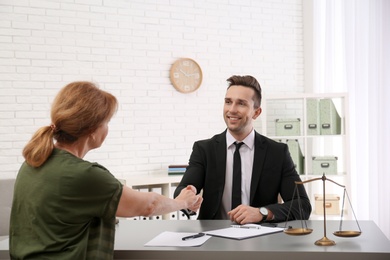 Young lawyer having meeting with senior client in office