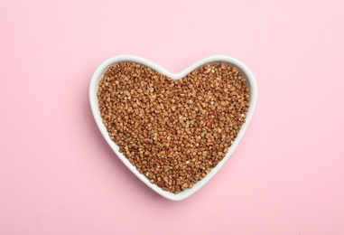 Buckwheat grains on pink background, top view