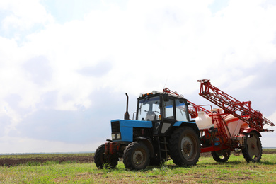 Modern agricultural equipment in field under cloudy sky