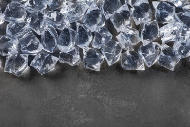 Pile of crushed ice on grey table, top view. Space for text