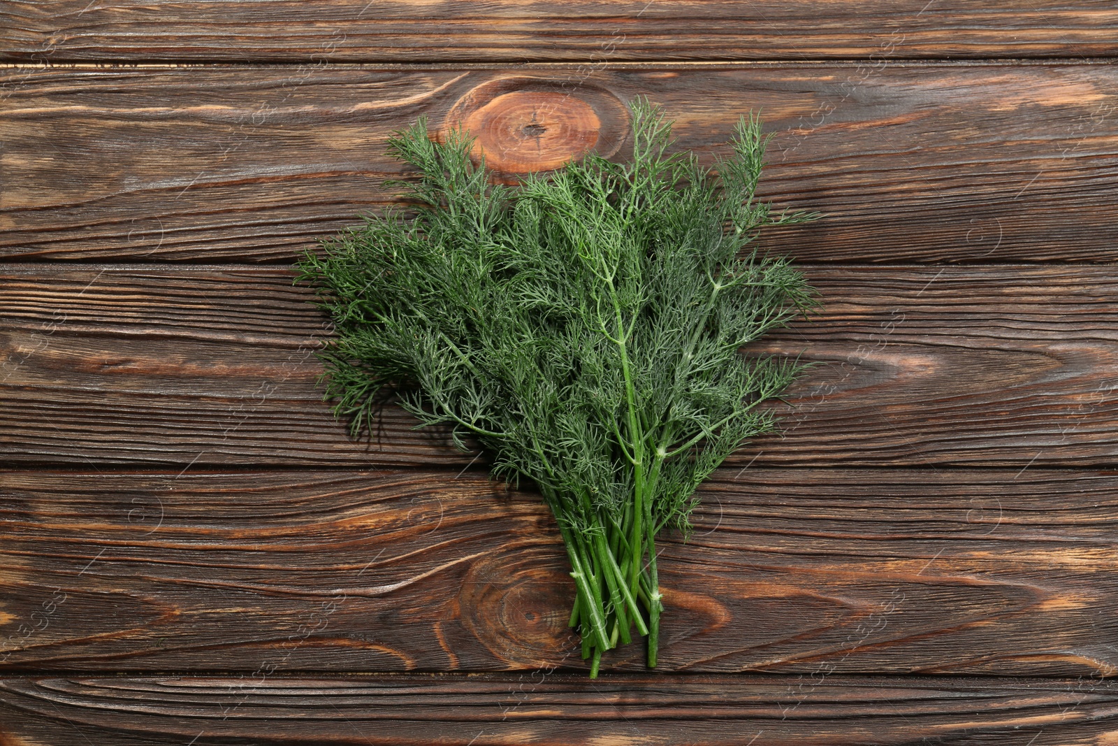 Photo of Bunch of fresh green dill on wooden table, top view