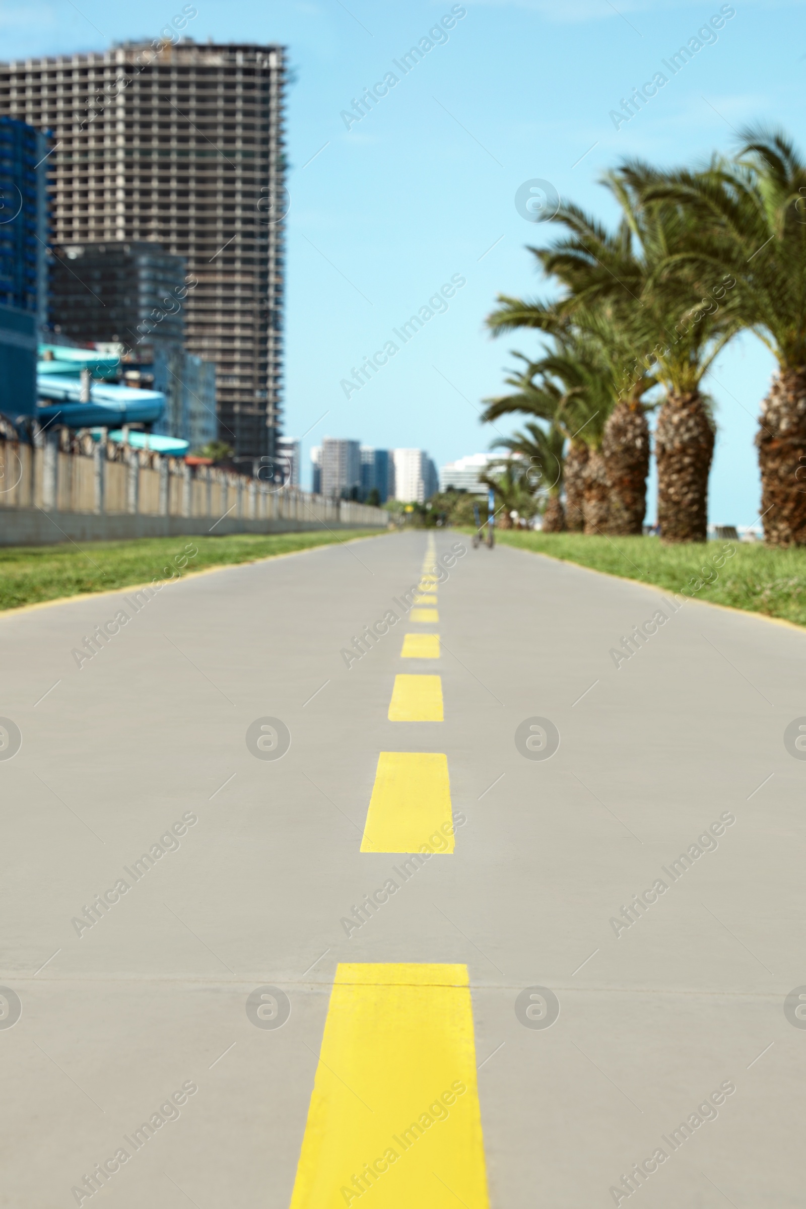 Photo of Bicycle lane with yellow dividing lines painted on asphalt, closeup