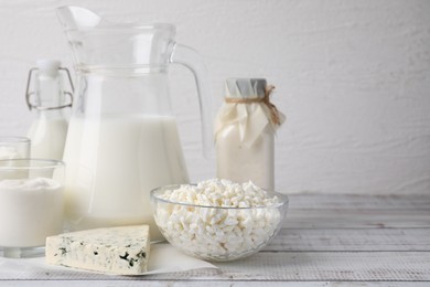 Different fresh dairy products on white wooden table. Space for text