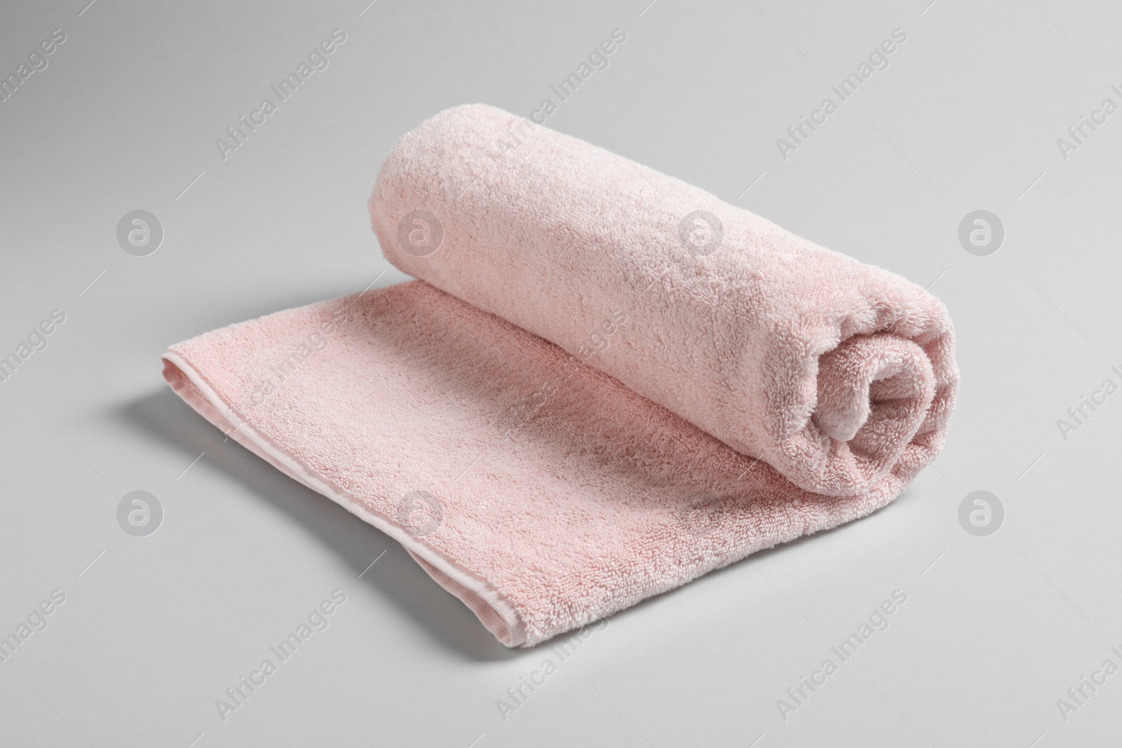 Photo of Fresh soft rolled towel on light background