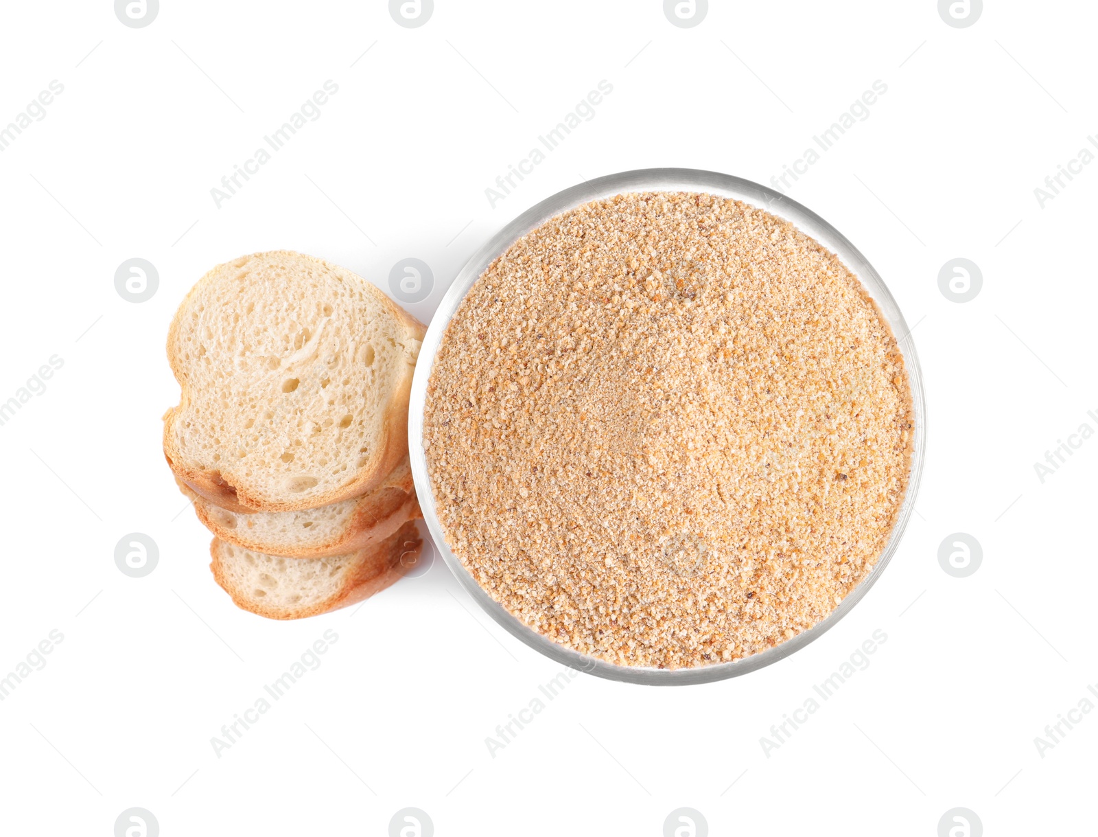 Photo of Fresh bread crumbs in glass bowl and slices of loaf on white background, top view