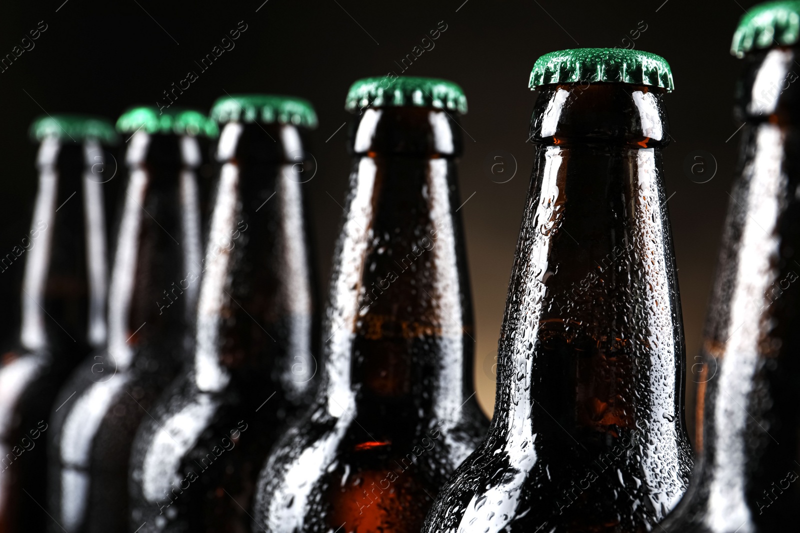 Photo of Many bottles of beer on dark background, closeup