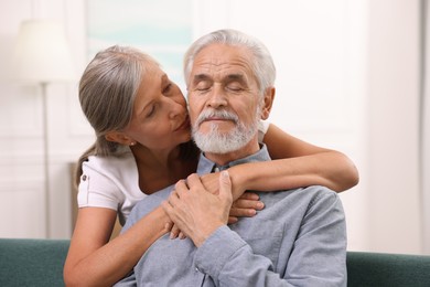 Photo of Senior woman kissing her beloved man indoors