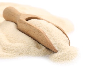 Photo of Scoop and uncooked organic semolina on white background, closeup