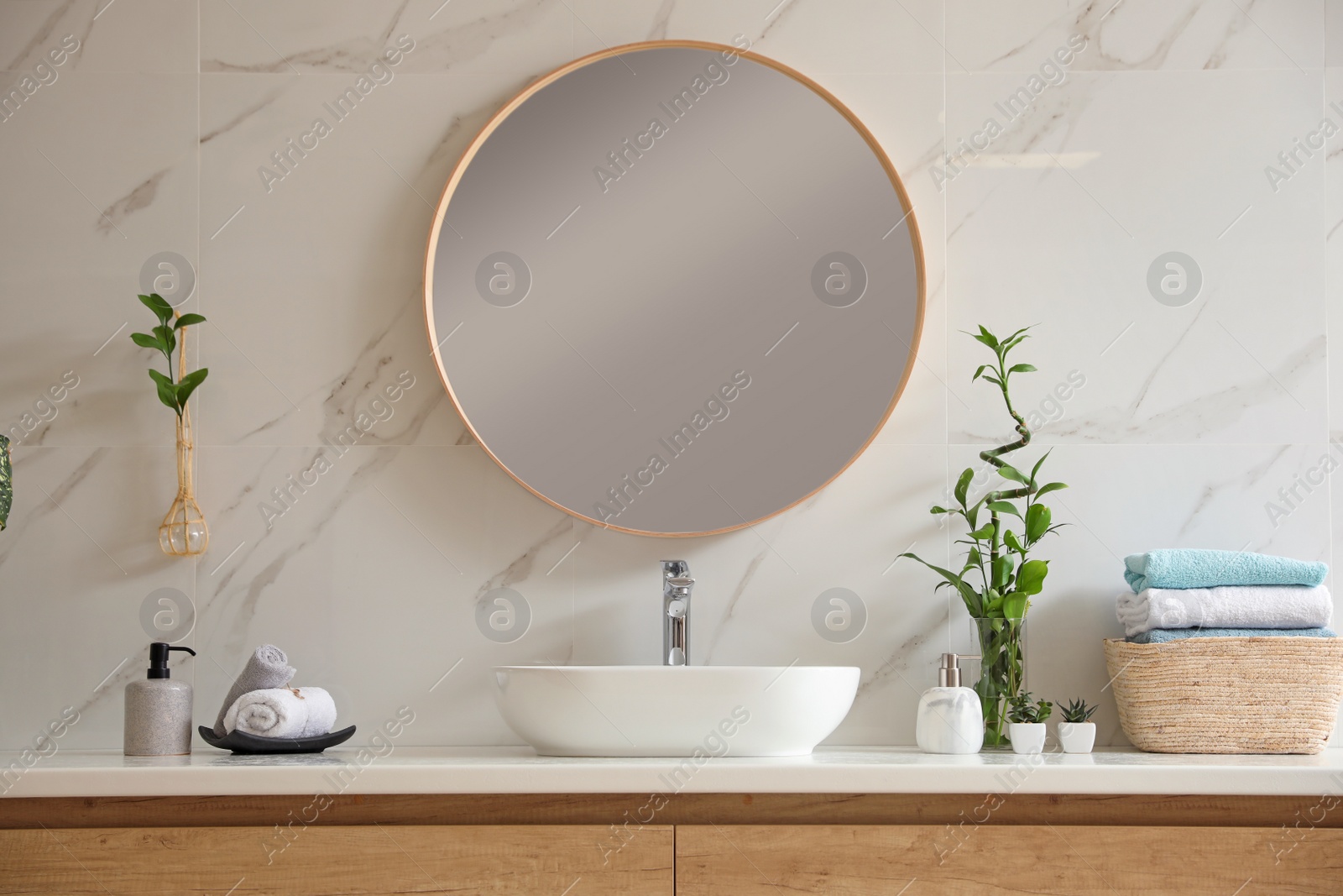 Photo of Beautiful green plants near vessel sink on countertop in bathroom. Interior design elements