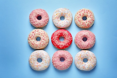 Photo of Delicious glazed doughnuts on color background, top view