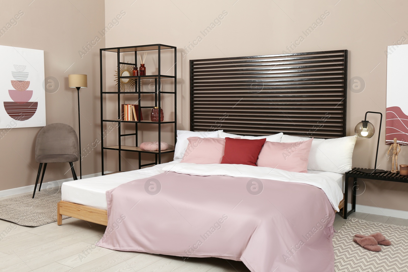 Photo of Large comfortable bed near beige wall in room. Interior design