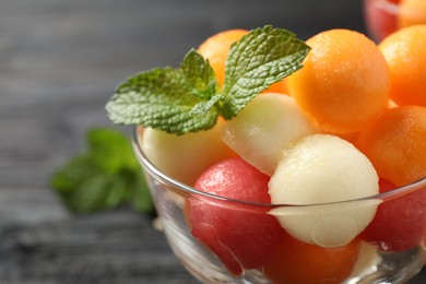 Photo of Melon and watermelon balls with mint in dessert bowl on table, closeup