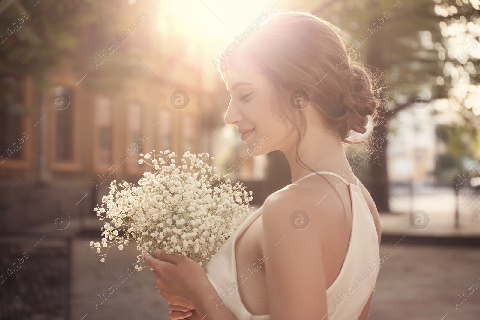 Photo of Gorgeous bride in beautiful wedding dress with bouquet outdoors