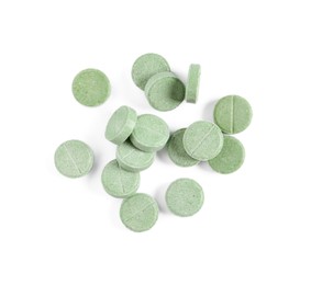 Pile of green pills on white background, top view