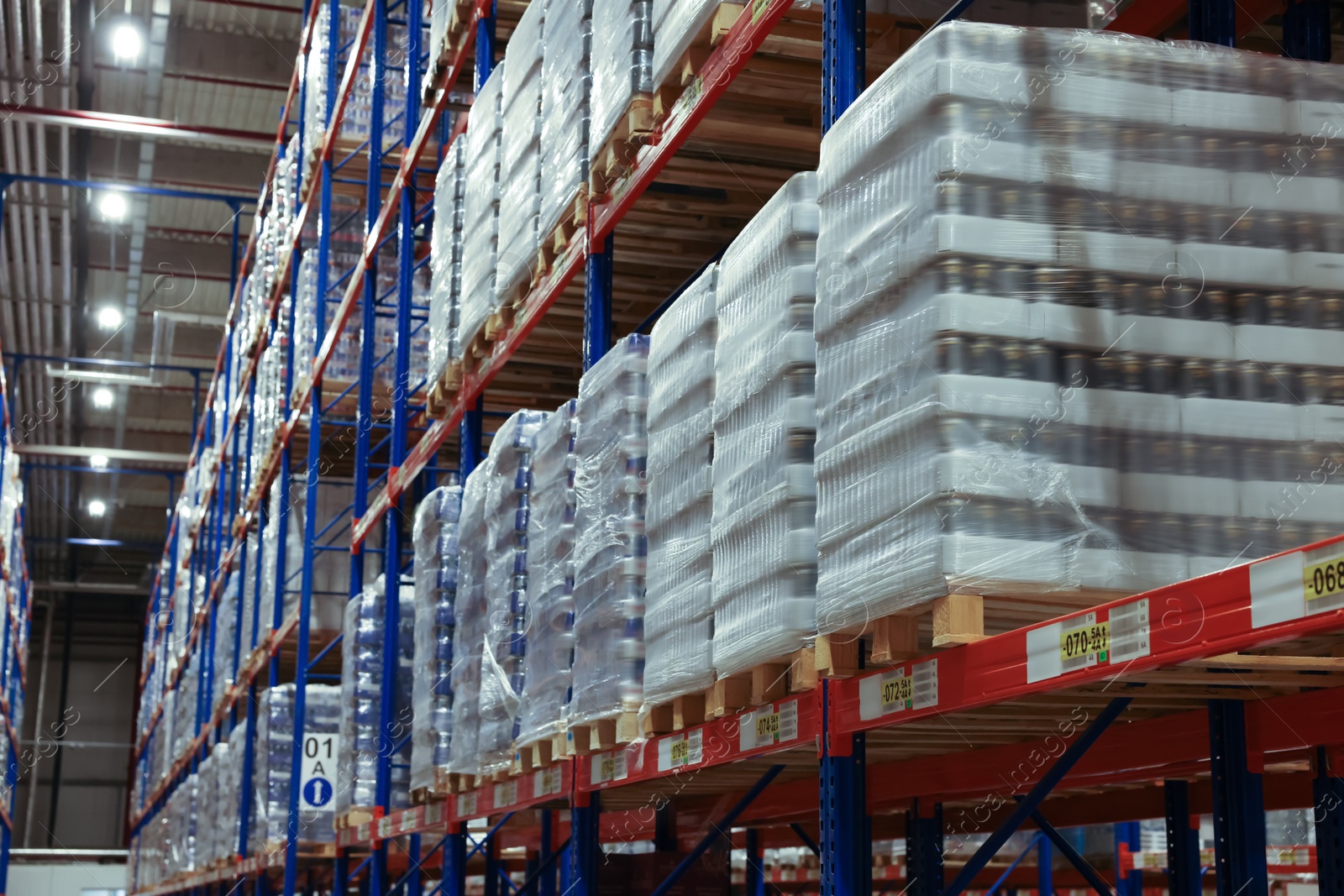 Photo of Warehouse interior with metal racks full of merchandise. Wholesale business