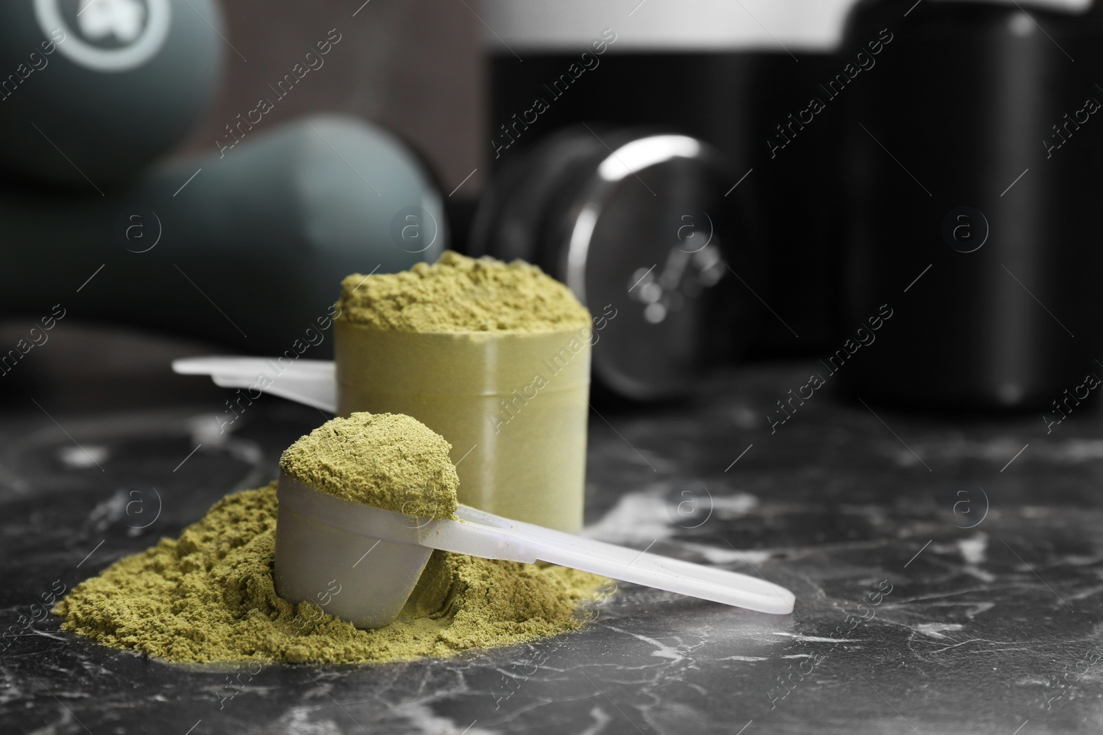 Photo of Measuring spoons with hemp protein powder on table. Space for text