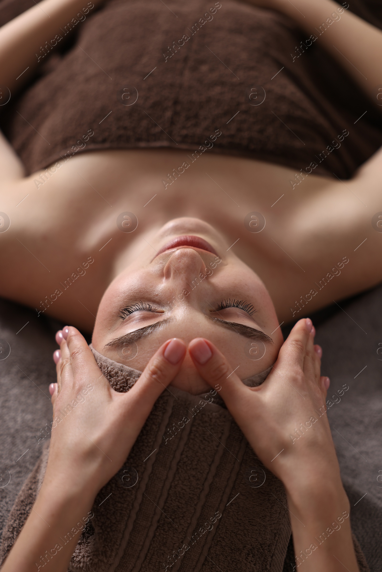 Photo of Spa therapy. Beautiful young woman lying on table during massage in salon