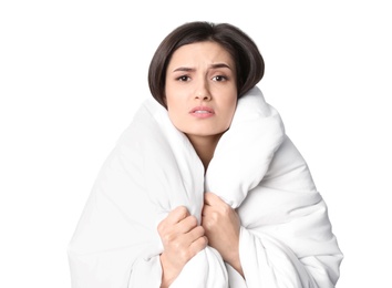 Young woman wrapped in blanket  suffering from cold on white background