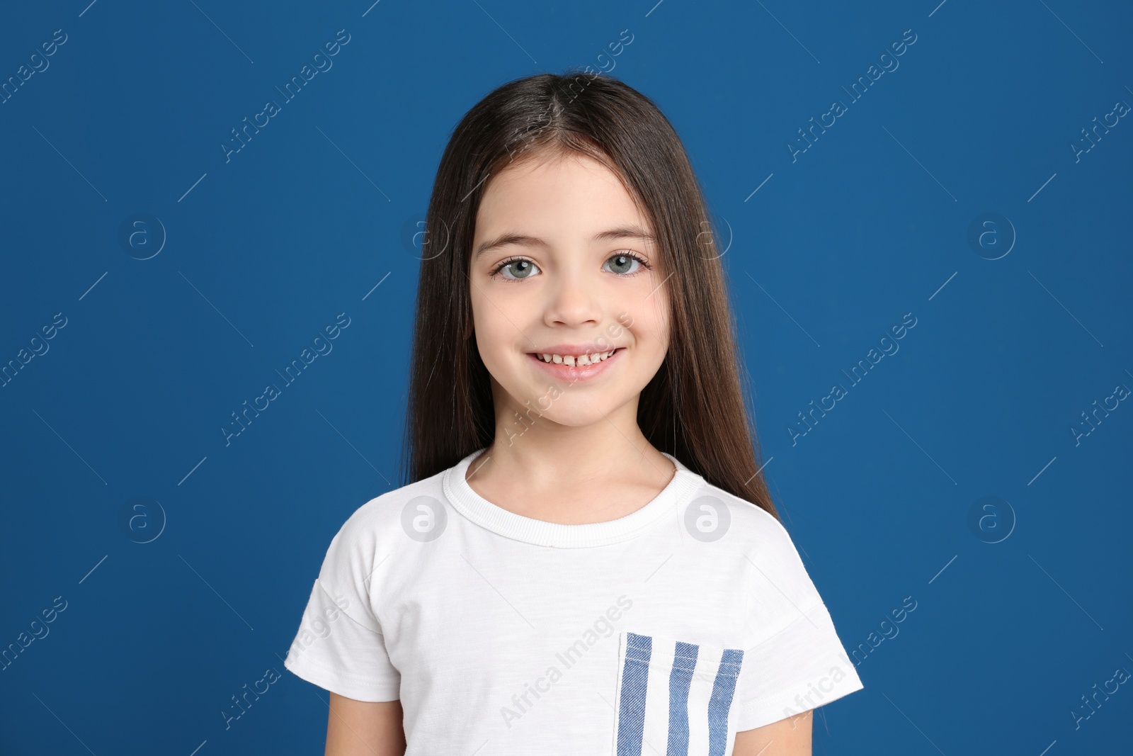 Photo of Portrait of cute little girl on blue background