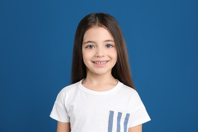 Portrait of cute little girl on blue background