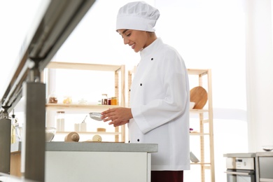 Female pastry chef preparing croissants at table in kitchen