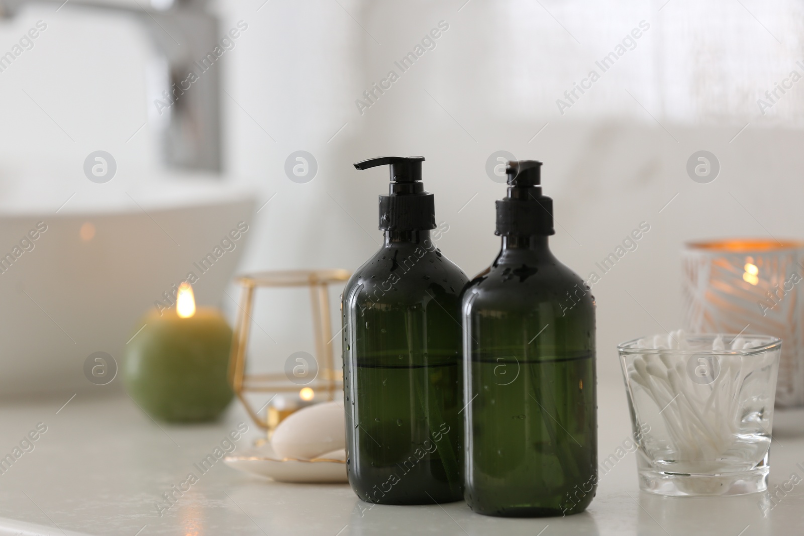 Photo of Green soap dispensers on white countertop in bathroom