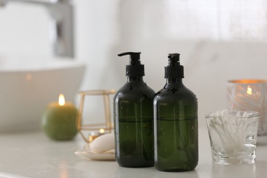 Photo of Green soap dispensers on white countertop in bathroom