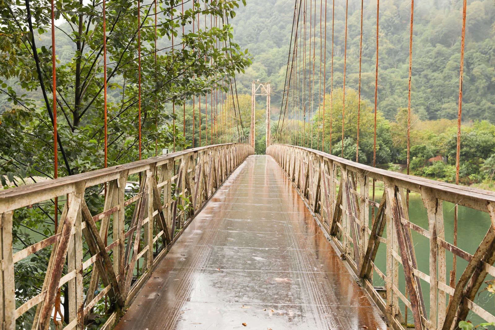 Photo of Beautiful view on rusty metal bridge over river in mountains