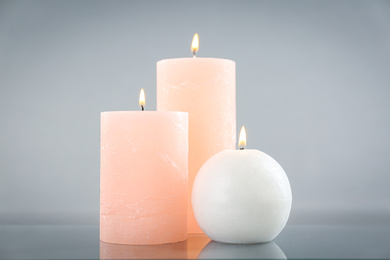 Photo of Aromatic  burning candles on light grey background