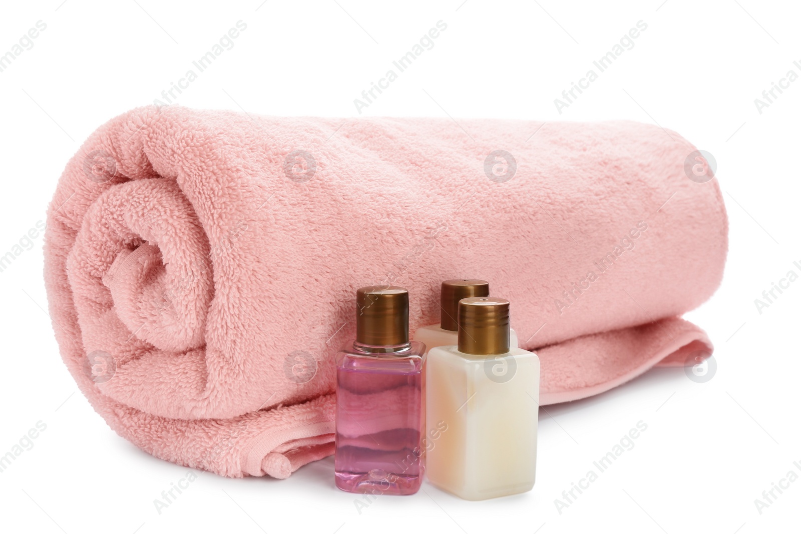 Photo of Mini bottles with cosmetic products and towel on white background. Hotel amenities